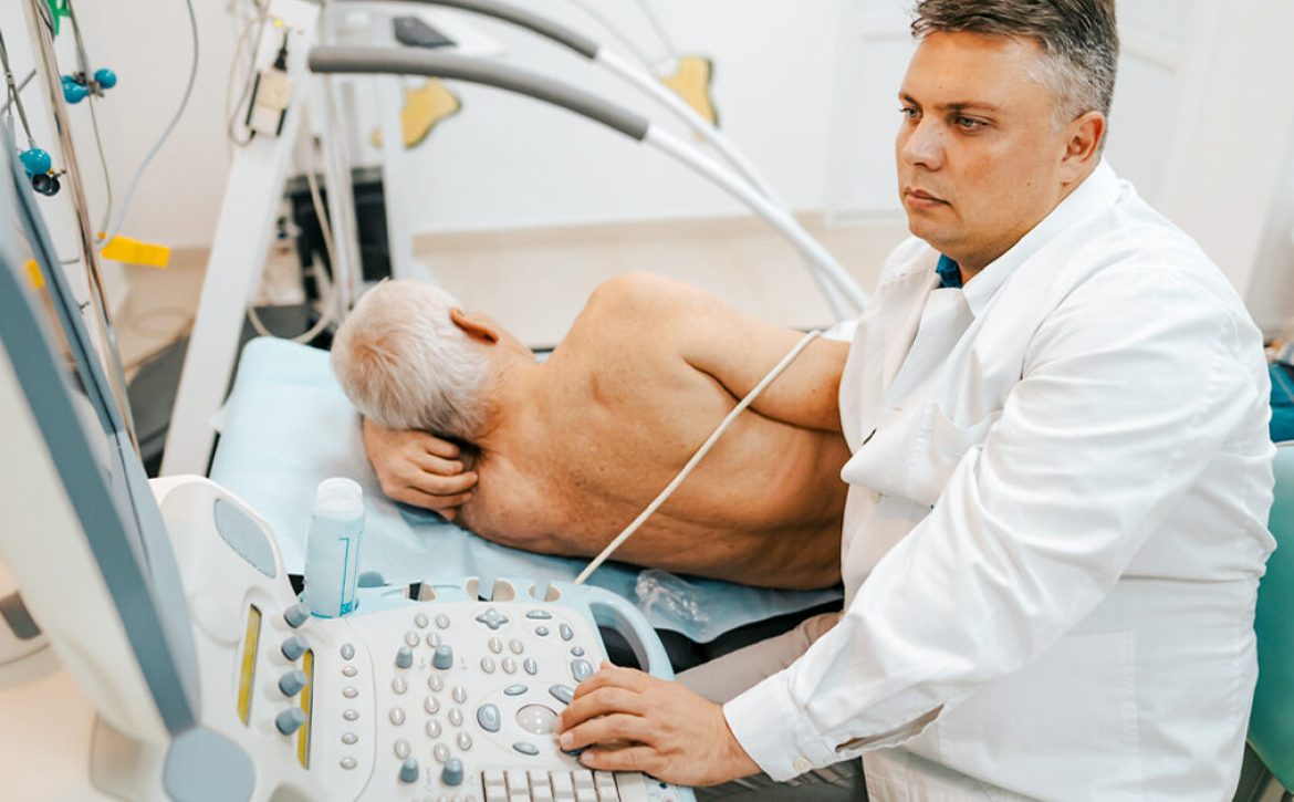 Male doctor examining a patient's heart by using an ultrasound equipment